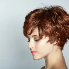 Krótkie, potargane włosy w odcieniu rudego brązu. Taka fryzura otwiera wiele możliwości, jakie można zrobić fryzury, od eleganckich upięć po rockowe stylizacje.