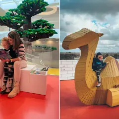 Dzieci bawią się w Lego House w Danii. Na lewo mama czyta książkę dziecku pod wielkim drzewem z klocków. Na prawo dziecko wspina się na wielbłąda z klocków.