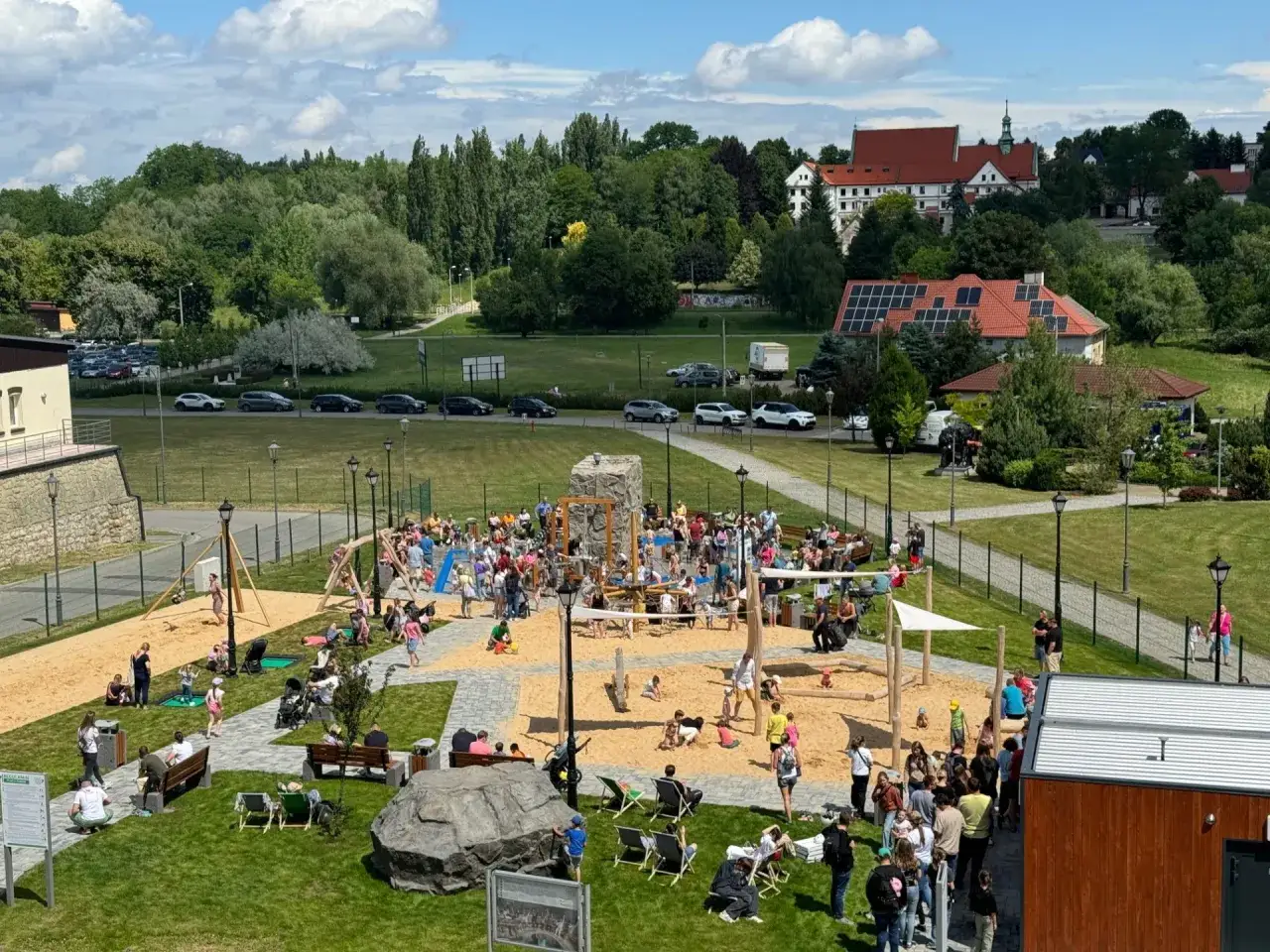 Tętniący życiem polsko-węgierski historyczny plac zabaw z piaskownicą, zjeżdżalniami i mnóstwem bawiących się dzieci.